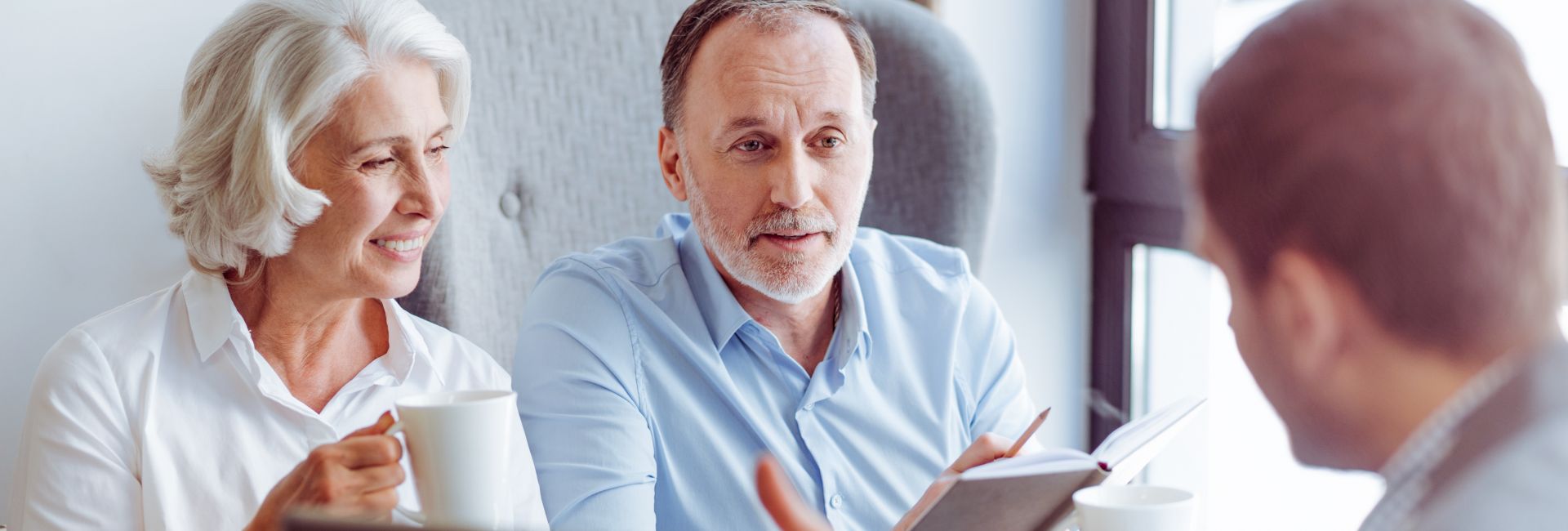 Mitte 50jähriger mit seiner Mutter bei einem Beratungsgespräch sitzend.